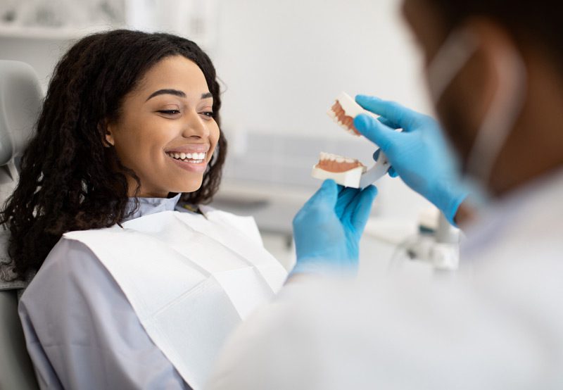 Doctor-consulting-patient-with-jaw-model