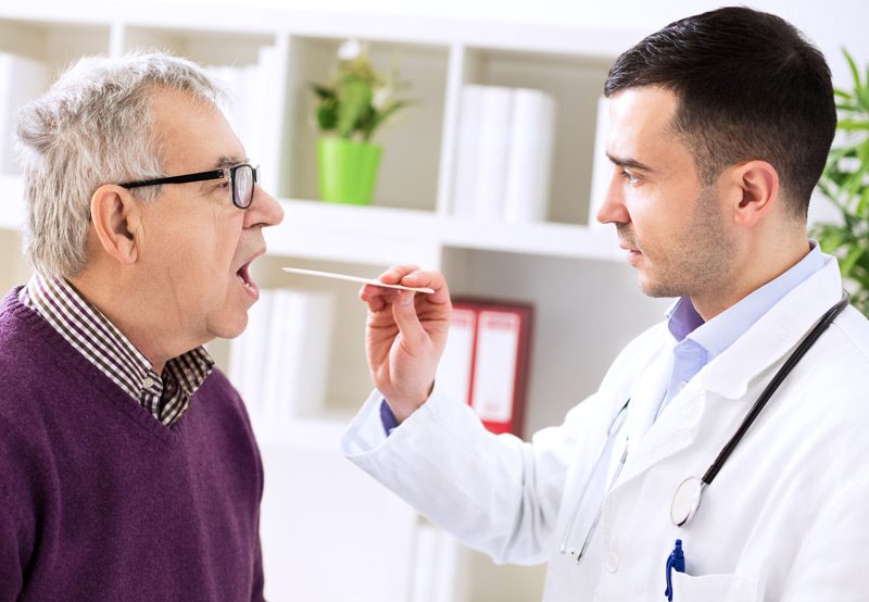 Doctor-examining-a-patient’s-throat