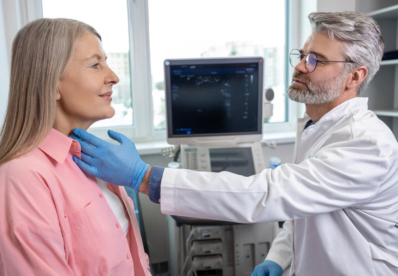 Male-doctor-palpating-patient’s-throat