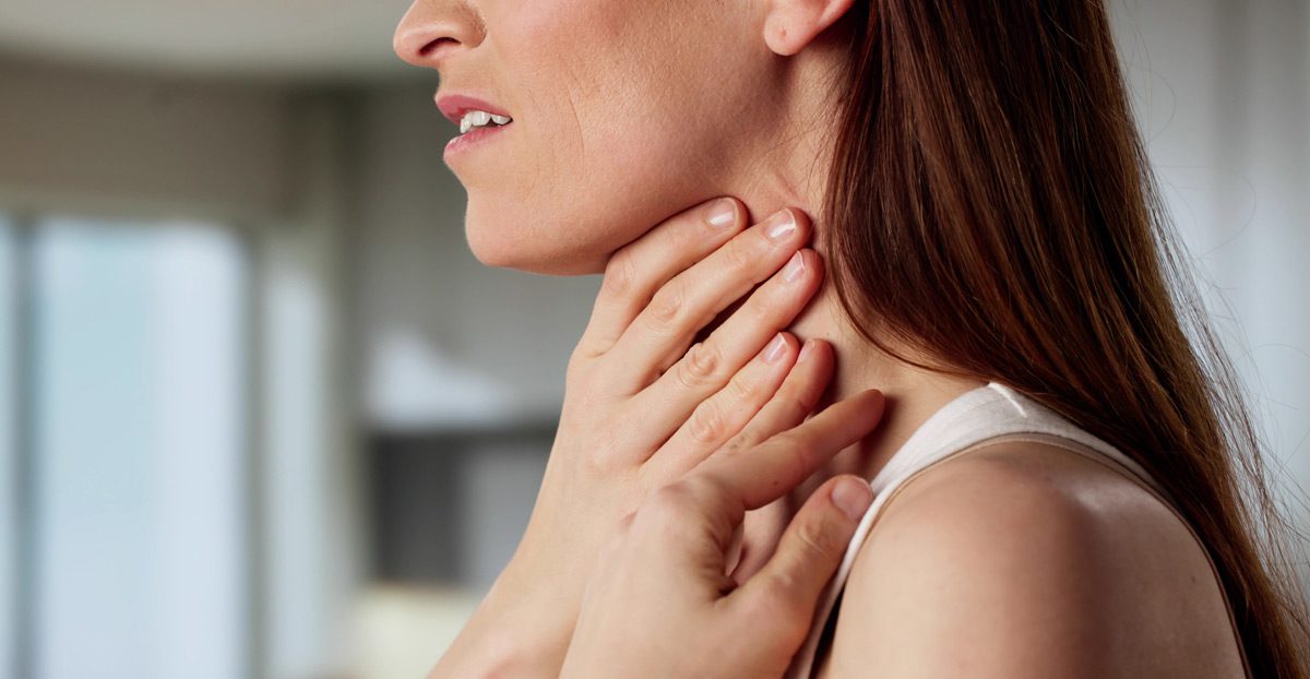 Woman-holding-throat-in-discomfort